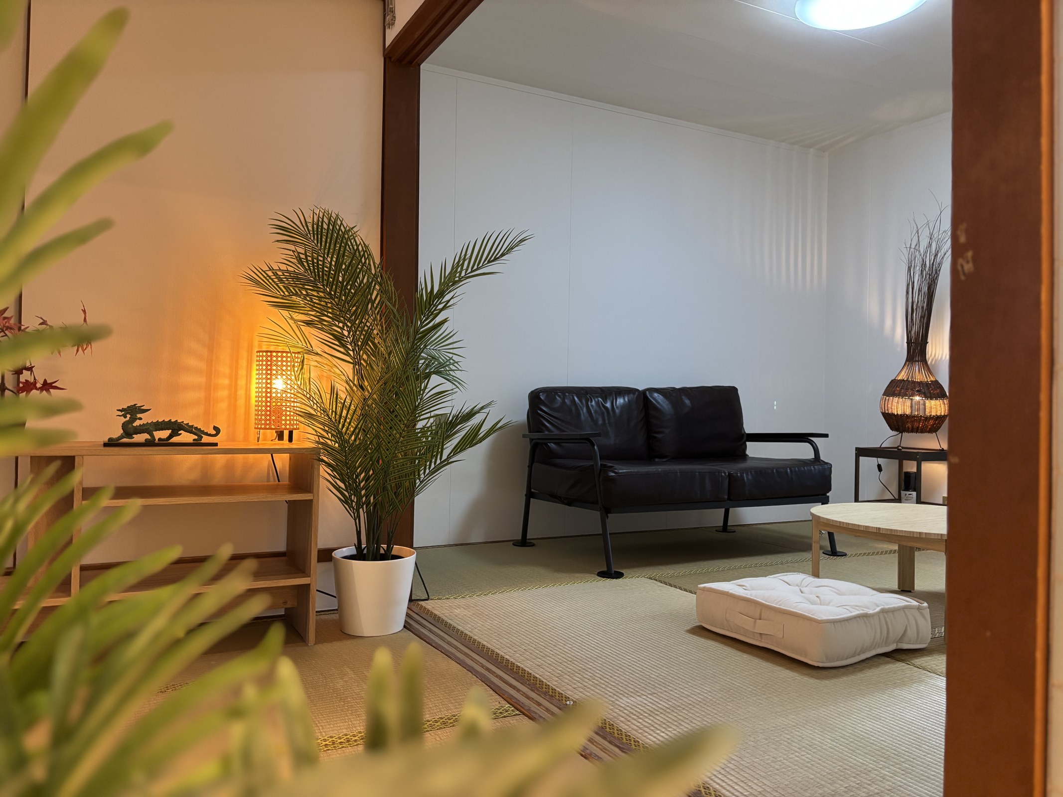 Autre espace de la maison Kujo, avec un canapé, une table basse et des plantes