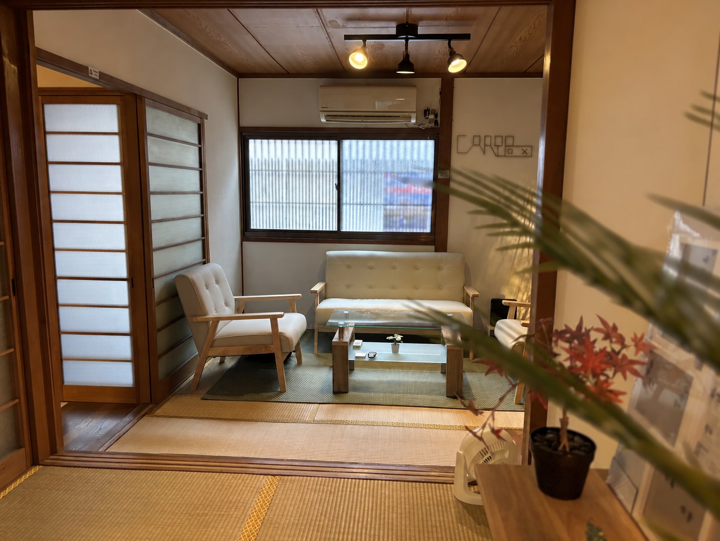 Maison CariBox Kujo — salon japonais avec une enseigne CariBox simulée sur le mur
